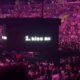 Momento del glitch en la pantalla del Crypto Arena mostrando el texto 1. Kiss Me de Ariana Grande